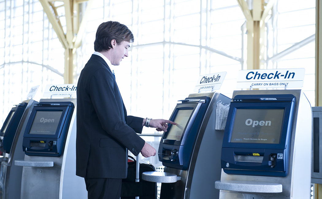 Virginia, USA --- Caucasian businessman checking-in at airport --- Image by © Dave and Les Jacobs/Blend Images/Corbis